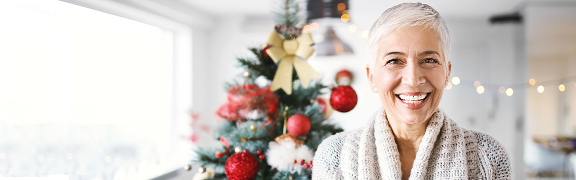 Una donna sorride con albero di Natale sullo sfondo Una donna sorride con albero di Natale sullo sfondo